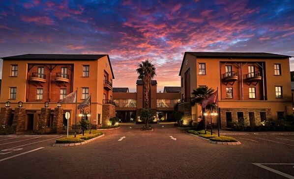 Stunning hotel facade with a central entrance and two wings, featuring brickwork and stone accents.