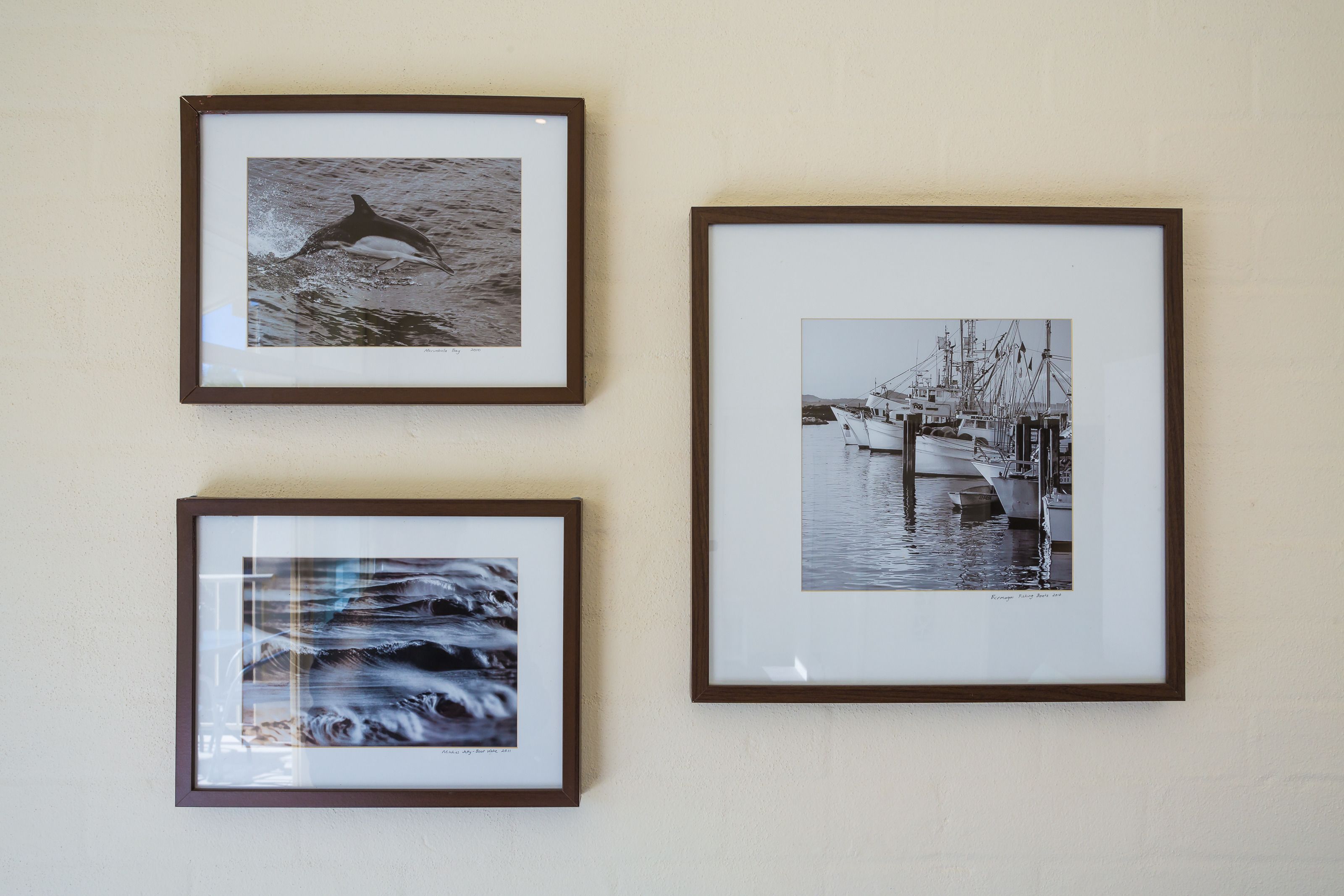 Drie ingelijste foto's aan een muur.
