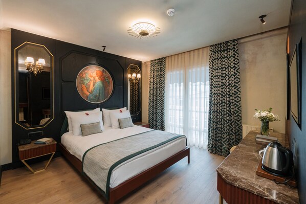 Ein modernes Hotelzimmer mit einem großen Bett, einem Nachttisch aus Holz, einer Marmorplatte im Badezimmer und einem großen Spiegel.