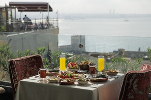 Ein Tisch, gedeckt für ein Frühstück, mit Blick aufs Meer.
