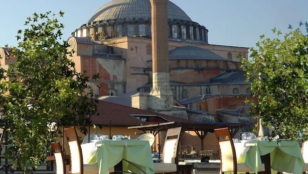 A historic building with a prominent dome and minaret, surrounded by trees and outdoor seating areas. - Tria Elegance Istanbul (Istanbul)