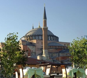 A historic building with a prominent dome and minaret, surrounded by trees and outdoor seating areas. - Tria Elegance Istanbul (Istanbul)