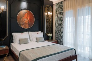 Ein ordentlich gemachtes Bett mit weißen Leinen und einem grünen Akzent, ein rundes Porträt darüber und ein gemustertes Vorhang auf der rechten Seite.