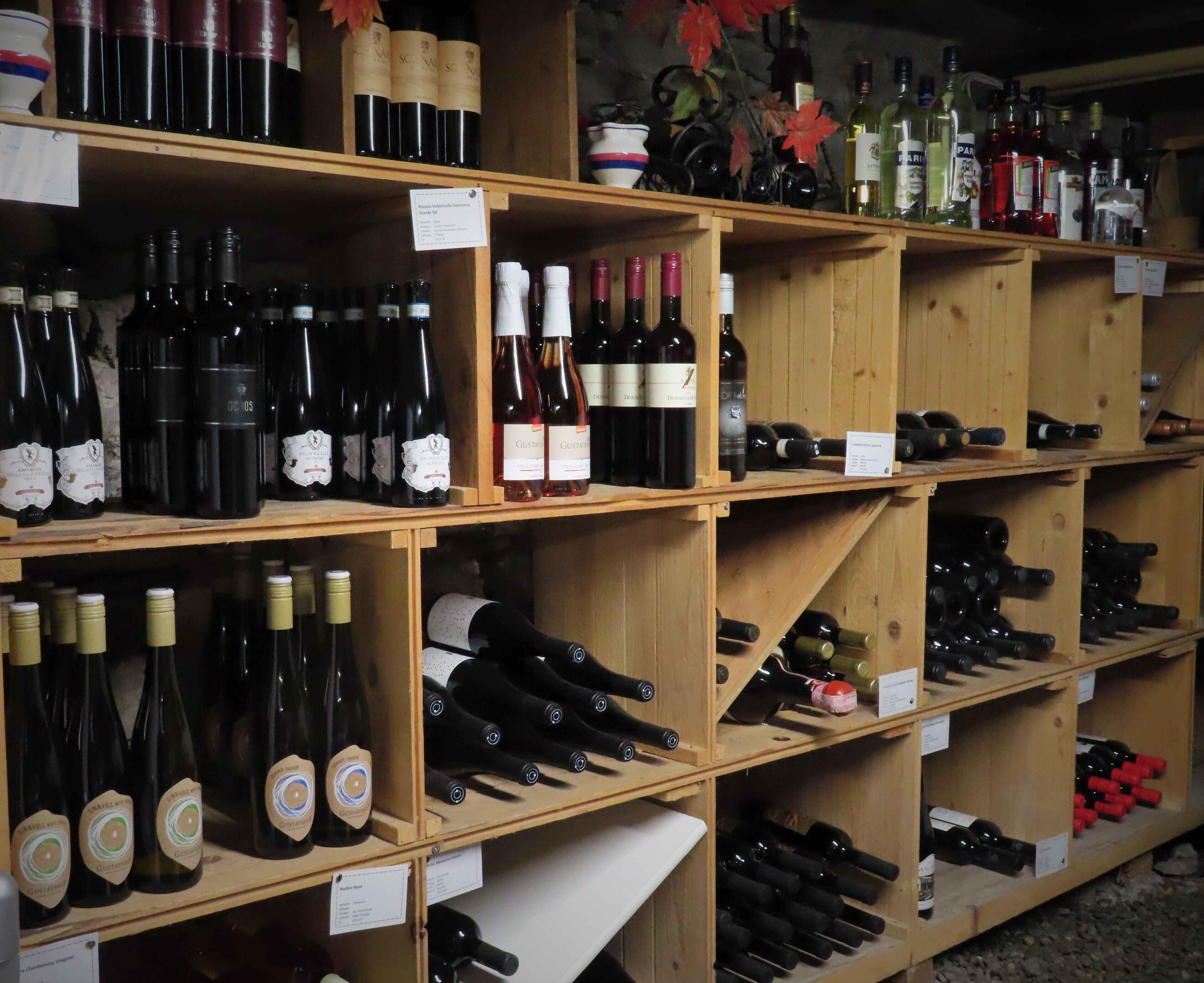 Une cave à vin avec des étagères en bois remplies de différentes bouteilles de vin.