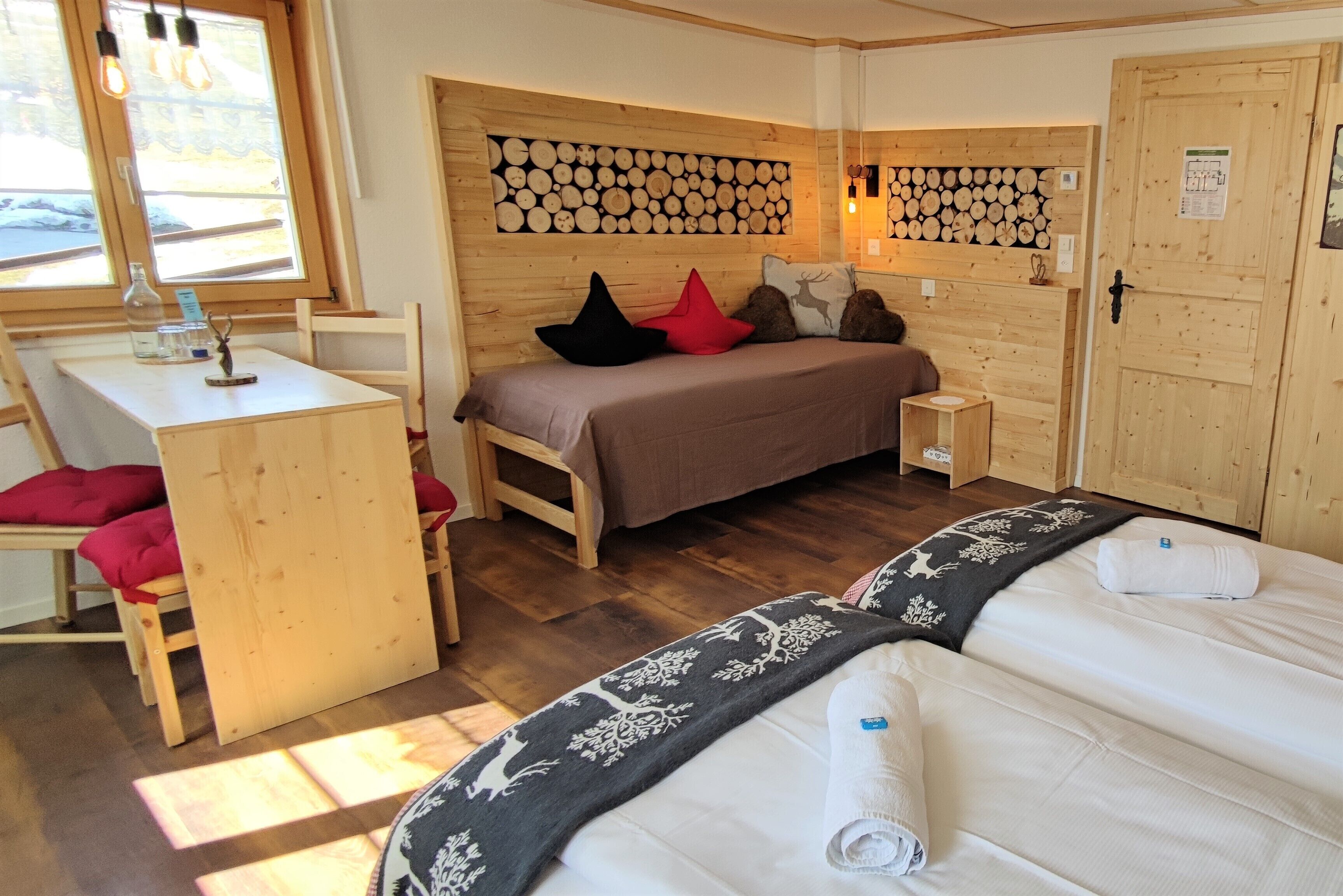 A cozy wooden room with a bed, a desk, and a chair.