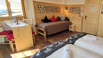 A cozy wooden room with a bed, a desk, and a chair.