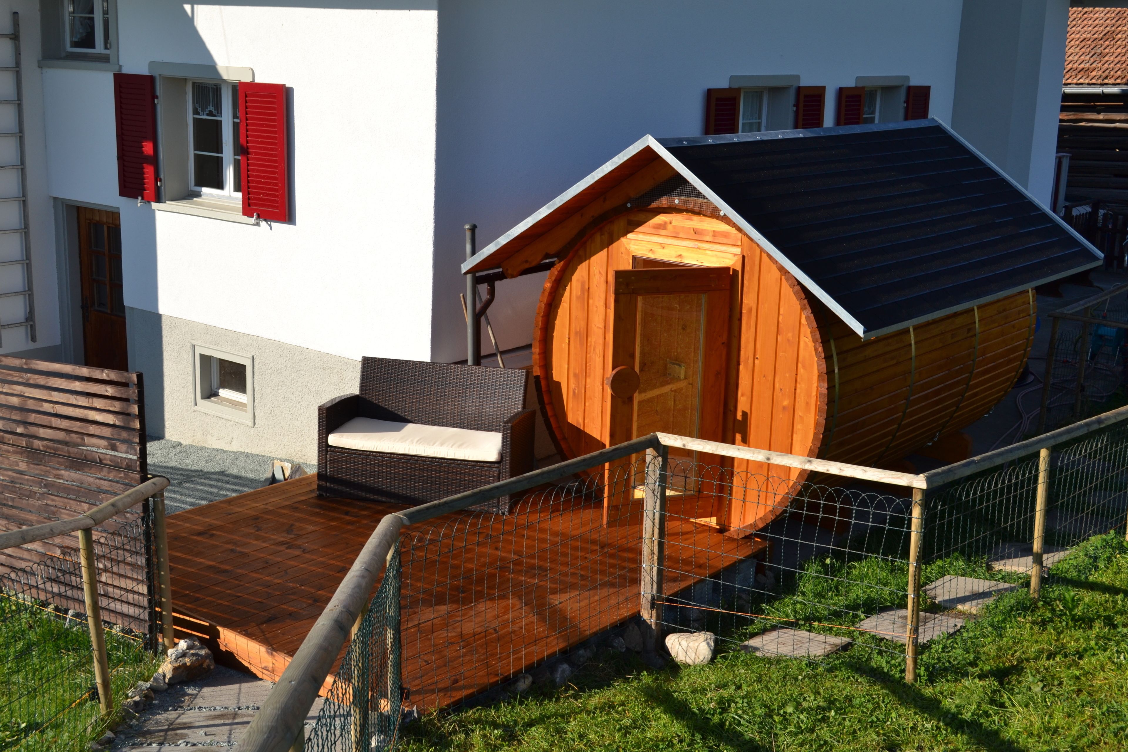 A wooden cabin with a sloped roof, a small porch, and a metal railing.