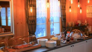Une cuisine aménagée avec un buffet, comprenant des assiettes, une planche à fromages et divers condiments.