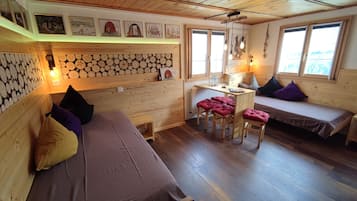 A cozy cabin interior with a wooden interior, a dining area, and two sleeping areas.