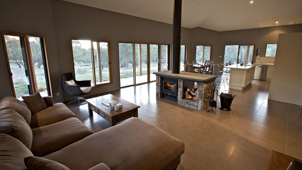 A spacious living area with a large sofa, a dining table, and a fireplace. - Snowy Wilderness (Ingebirah)
