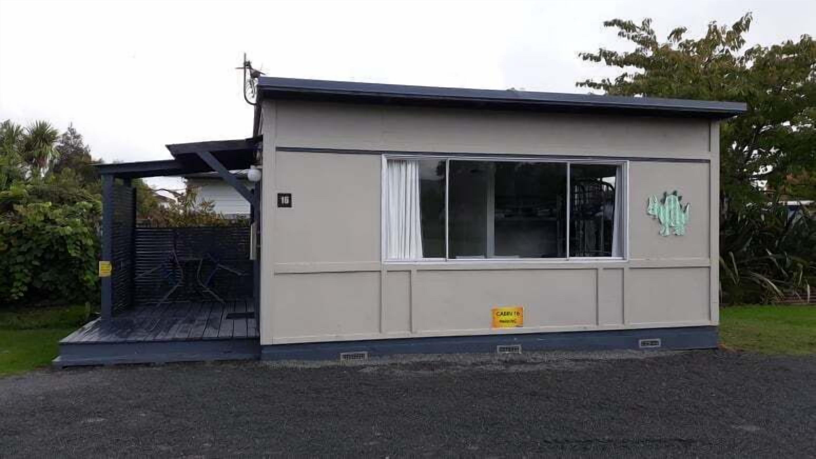A small, single-story building with a flat roof and a large window.