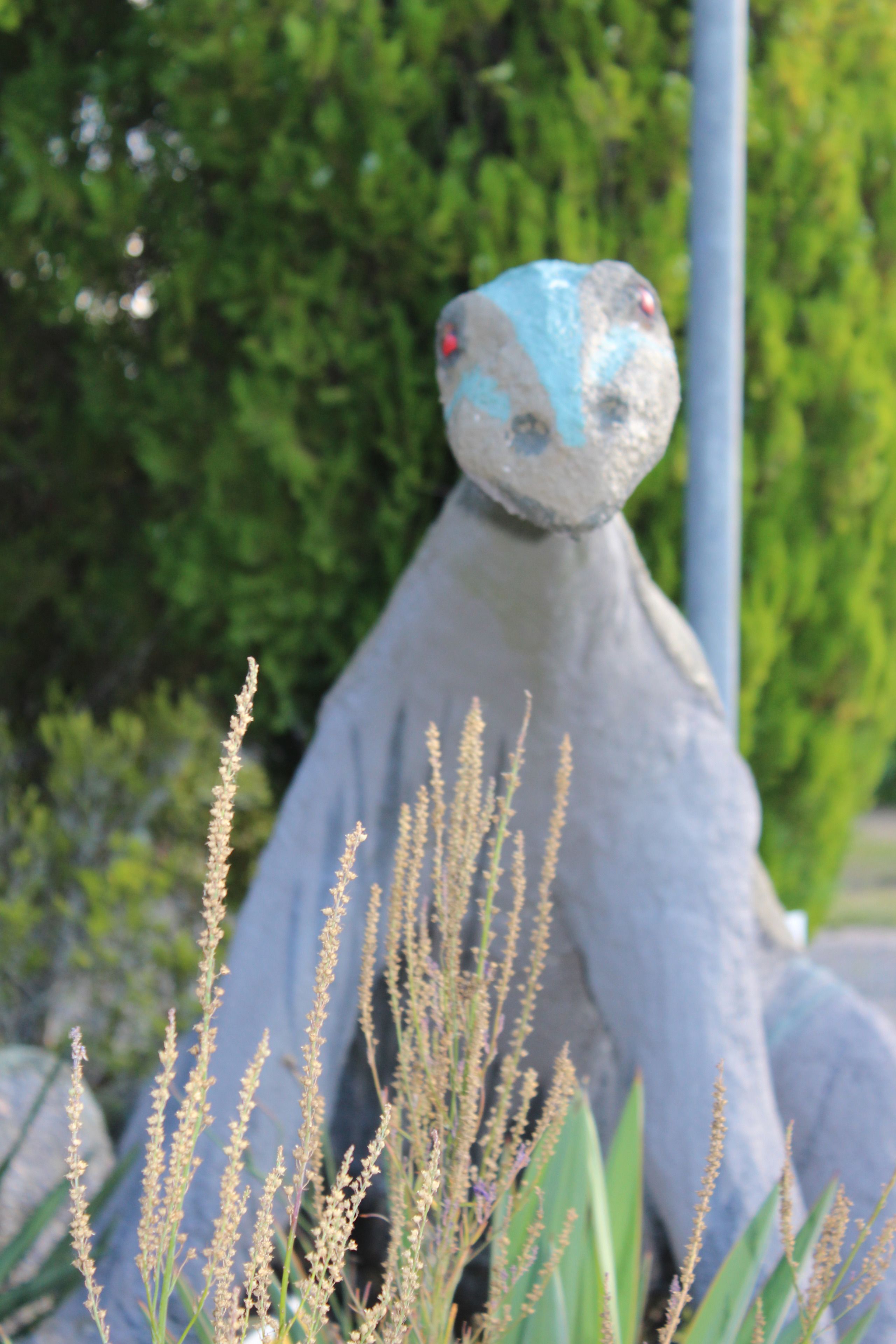 Una escultura de una figura humanoide con superficie texturizada y una paleta de colores azul y gris.