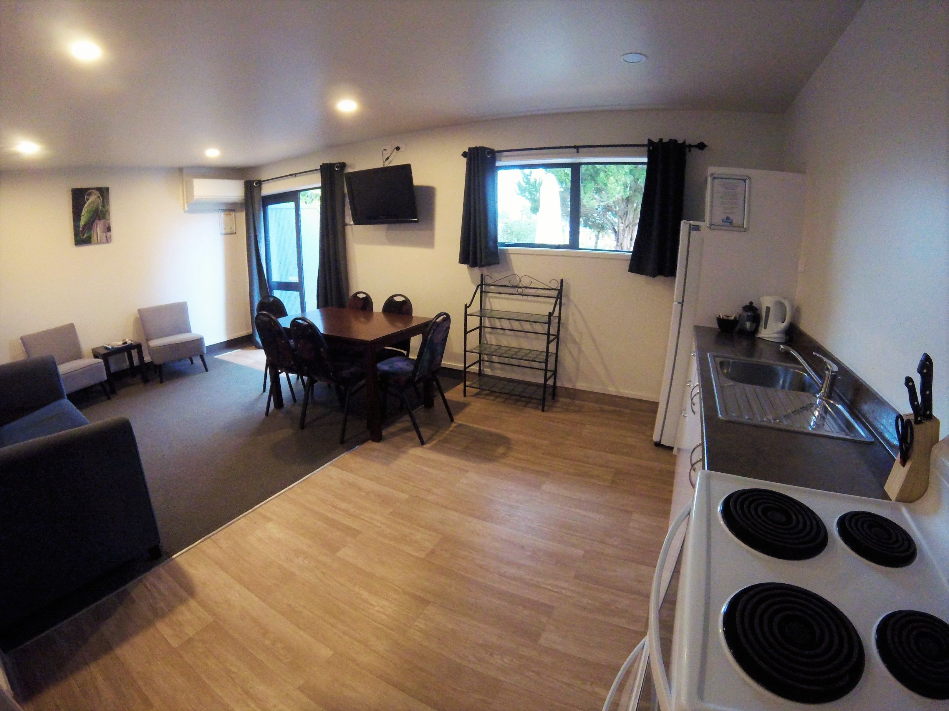 Un espace de vie compact comprenant un coin repas, une kitchenette et un coin salon.