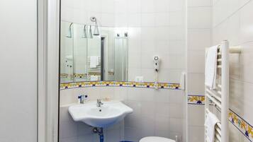 A bathroom with a sink, toilet, and bidet.