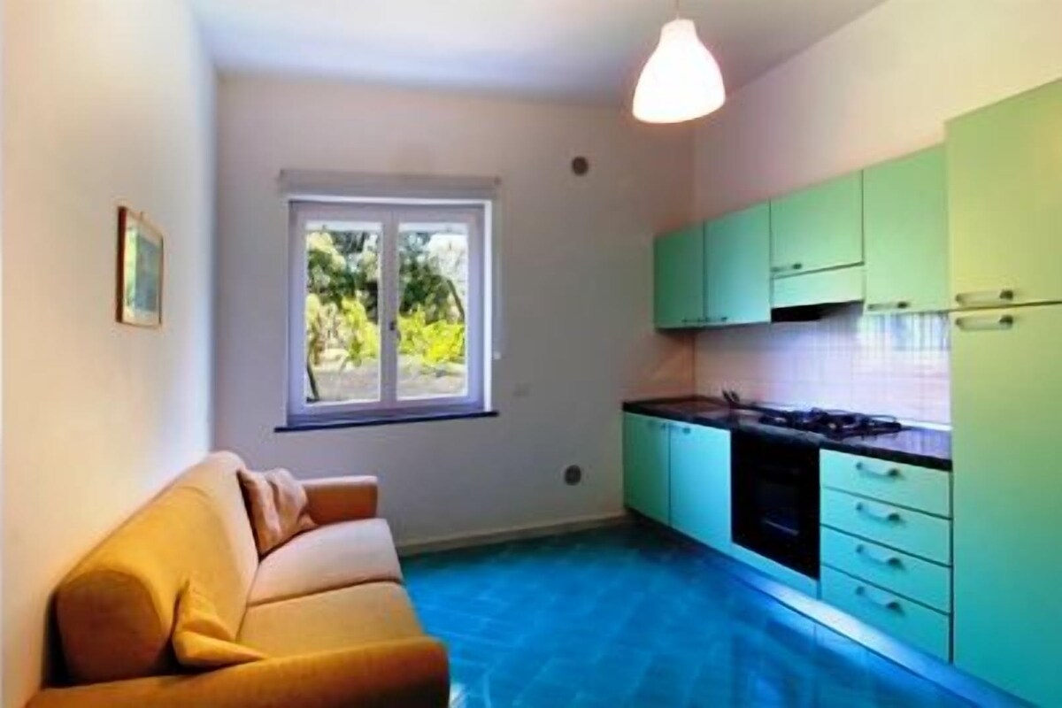 A compact living space with a kitchenette, a bathroom, and a bedroom.