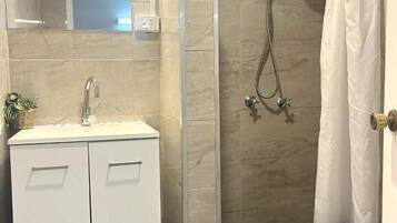 Deluxe vierpersoonskamer | Badkamer | Een douche, gratis toiletartikelen, een haardroger, handdoeken