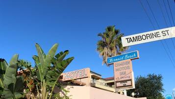 Um motel com uma placa indicando 'MOTEL' e 'TAMBORINE ST'.