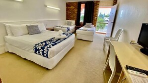 Une chambre d’hôtel avec deux lits, un bureau, une chaise, une télévision et un balcon avec vue.