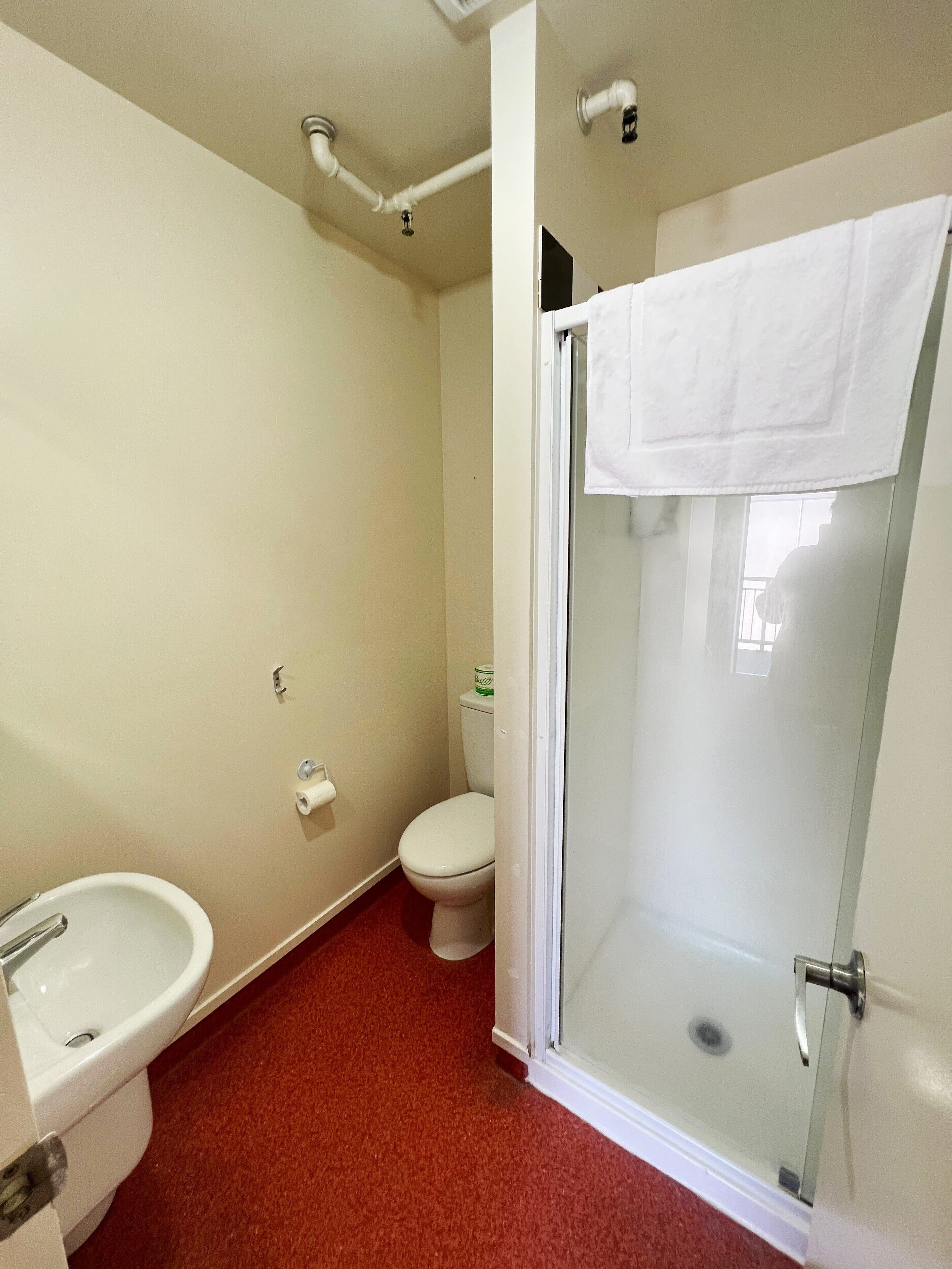 A bathroom with a toilet, sink, and shower.