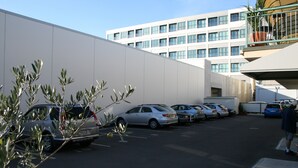 A parking lot with several cars and a building in the background. - Astray Motel (Rotorua)