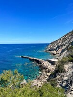Una playa cerca, arena negra, sombrillas, toallas de playa