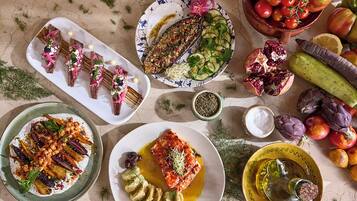 Diversos platos con pescado, verduras y frutas, sugiriendo una comida.