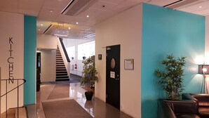 A modern hotel lobby with a staircase, a reception desk, and a seating area. - Hotell Centralstation (Uppsala)