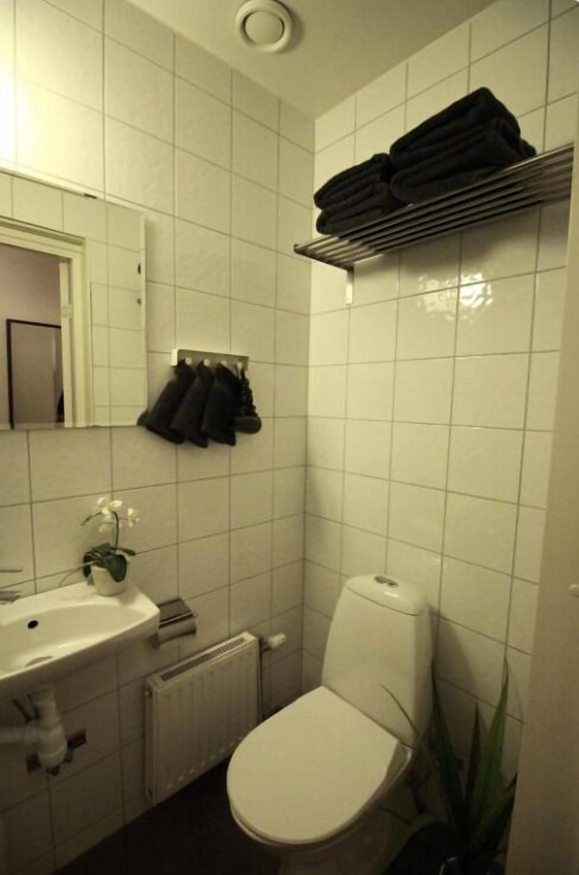 A bathroom with a toilet, sink, and towel rack.