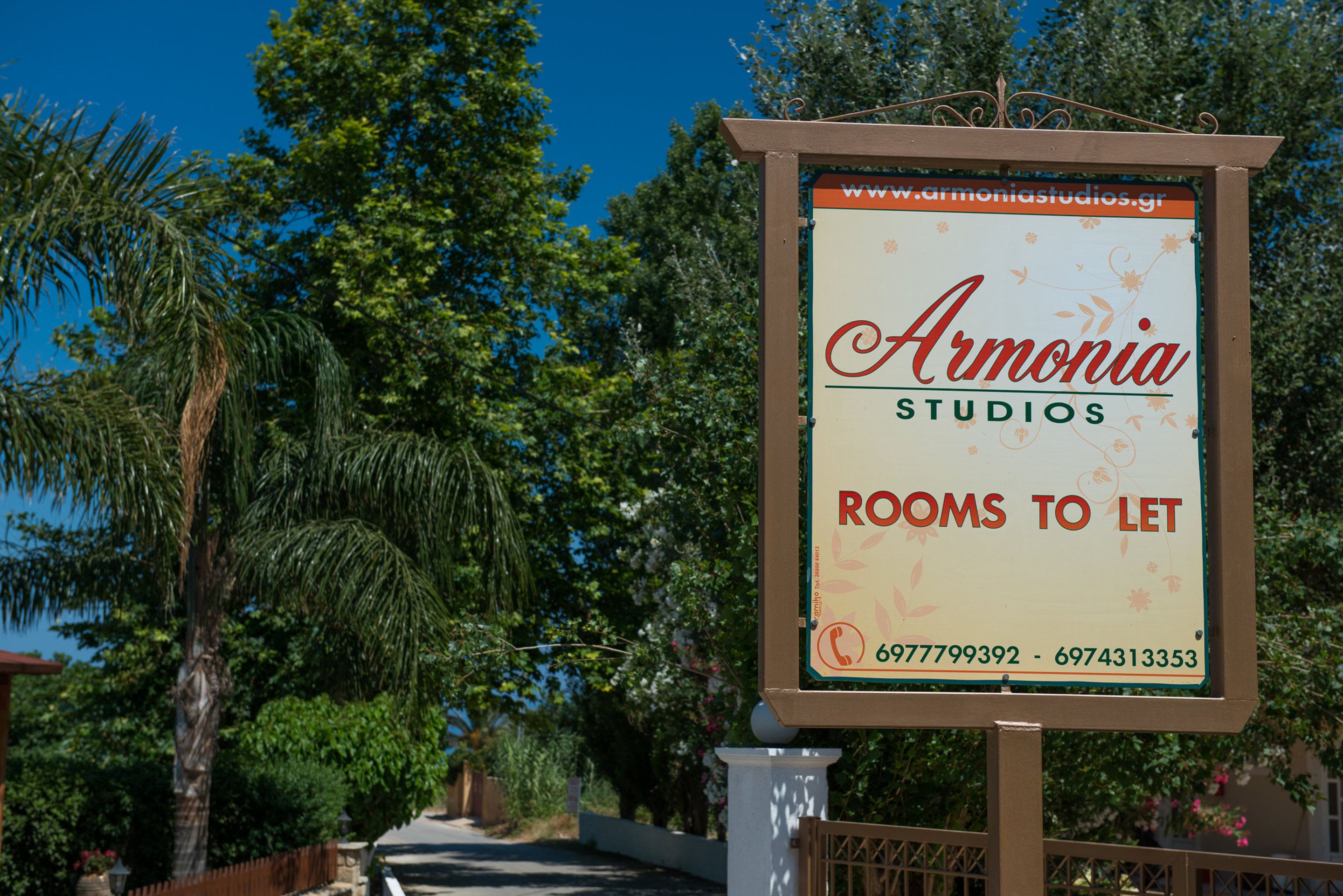 A sign for 'Armonia Studios' advertising rooms for rent.