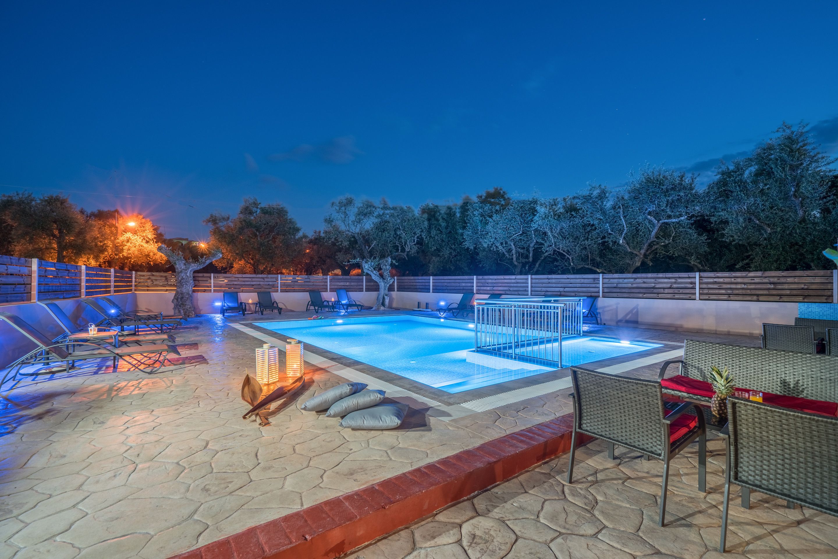 An outdoor swimming pool area with lounge chairs and a barbecue setup.