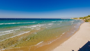 A beach with clear turquoise water, sandy shore, and a clear sky. - Armonia Studios & Apartments (Zakynthos)