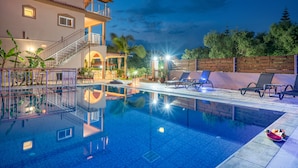 A swimming pool with a clear view of the pool area, including lounge chairs and a staircase leading to an upper level. - Armonia Studios & Apartments (Zakynthos)