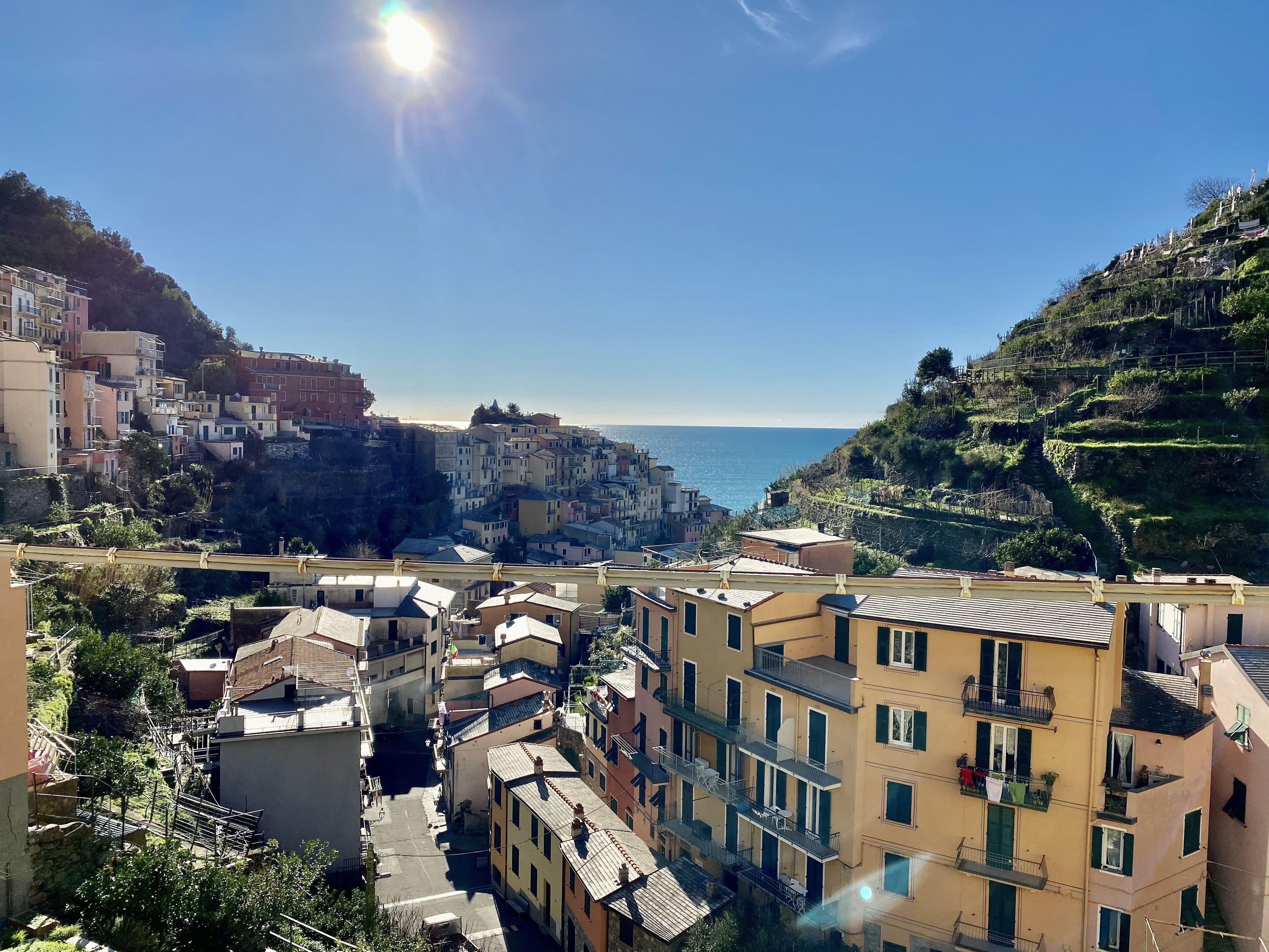 Un borgo costiero con edifici a terrazze, strette vie e vista sul mare.