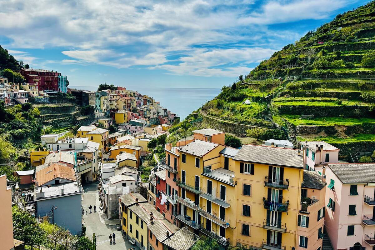 A coastal town with terraced houses, a clear sky, and a view of the sea.
