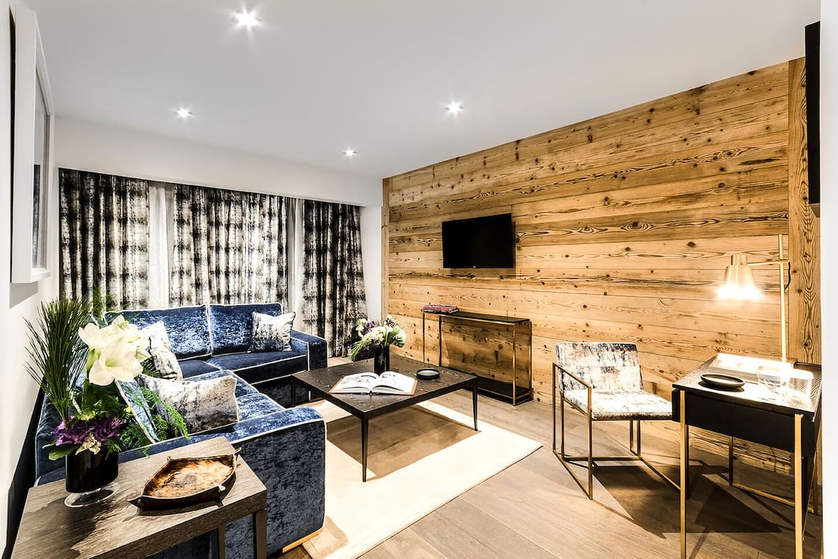 Una sala moderna con un sofá azul, una mesa de centro y una chimenea.