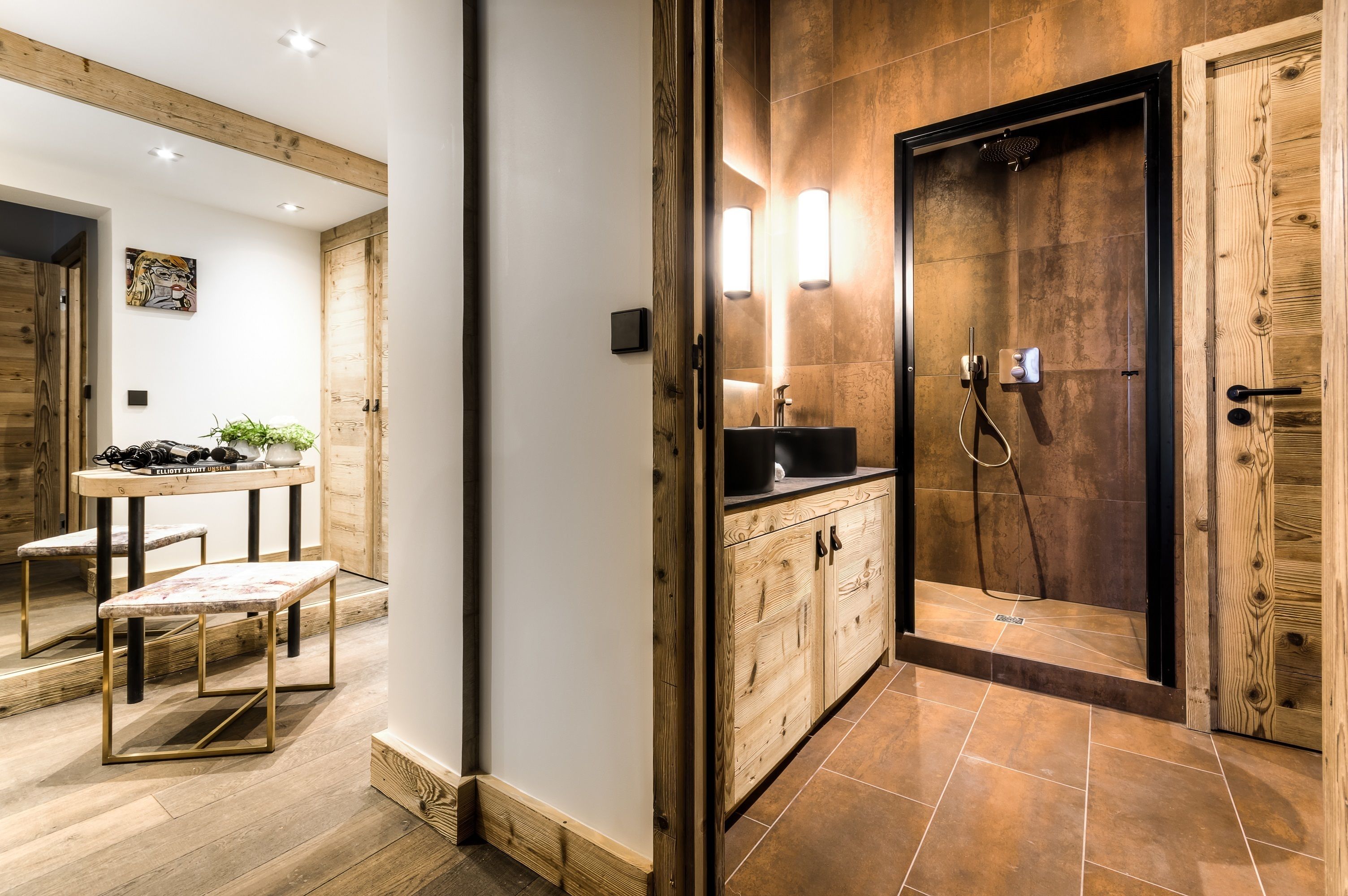 Une salle de bain moderne avec un meuble-lavabo en bois, une douche avec une porte en verre et une petite table avec des tabourets.