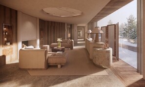A modern interior with a sofa, armchair, and side tables, a fireplace, and a view of a snowy landscape. - Sivolière Hôtel & Résidence (Courchevel)