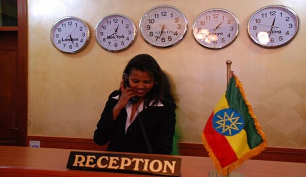 A reception area with clocks displaying different time zones, a flag, and a sign reading "RECEPTION".