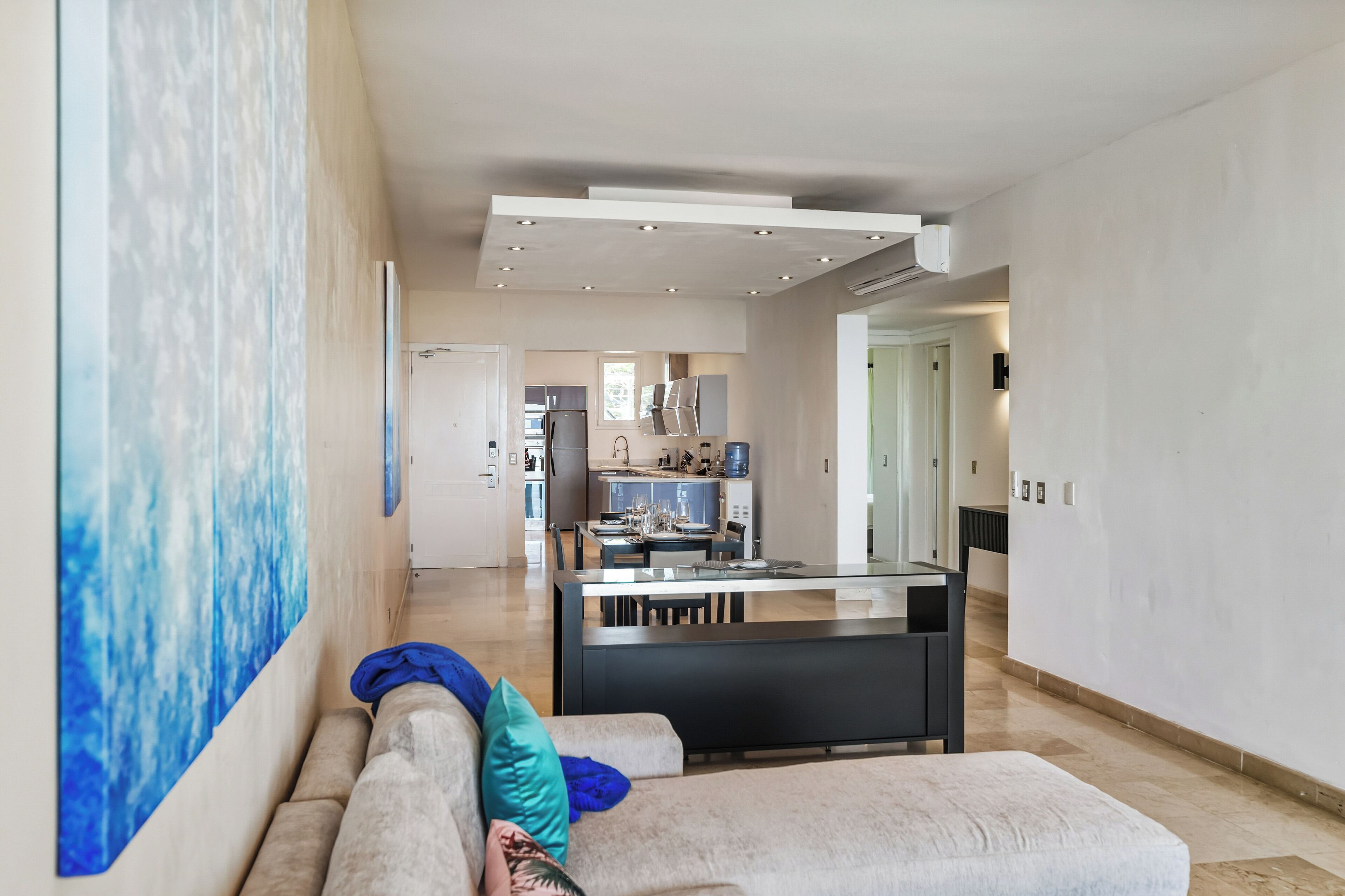 Una sala moderna con un sofá y un comedor al fondo.
