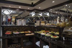 A buffet setup with various food items and a coffee station.