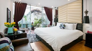 A modern hotel room with a large bed, a seating area with a table, and a view of the outside. - Splendid Star Grand Hotel & Spa (Hanoi)