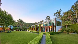 Una casa moderna con césped cuidado, un sendero y una escalera que conduce a la entrada.
