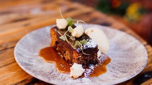 A dessert on a plate with a wooden table background. - The Cricketers Arms (Saffron Walden)