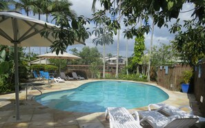 Una piscina al aire libre, una piscina climatizada, sombrillas