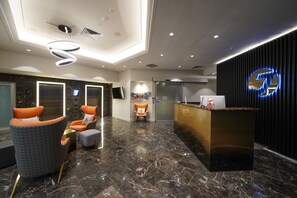 A modern lobby with marble flooring, a reception desk, and seating areas. - Jephson Hotel & Apartments (Toowong)