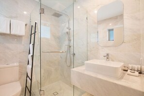 A modern bathroom with a glass-enclosed shower, a white sink, and a large mirror. - Jephson Hotel & Apartments (Toowong)