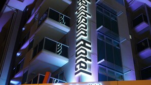 A Jephson Hotel building with illuminated signage, multiple balconies, and a modern architectural design.