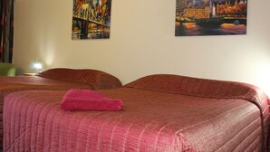 A hotel room with two beds, a pink towel on the bed, and two paintings on the wall. - Motel Mount Gambier (Mount Gambier)