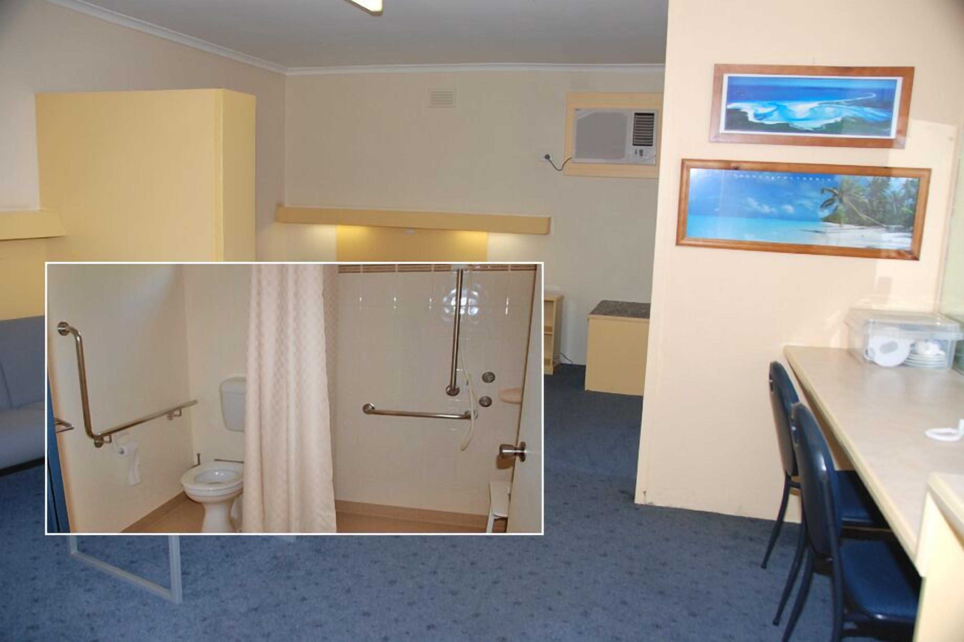A room with a bathroom, a dining area, and a small kitchenette.
