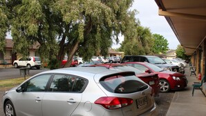 A parking lot with several cars parked in front of a building with a covered walkway. - Motel Mount Gambier (Mount Gambier)